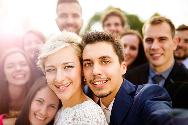 istock Newlyweds with friends taking selfie 517194185