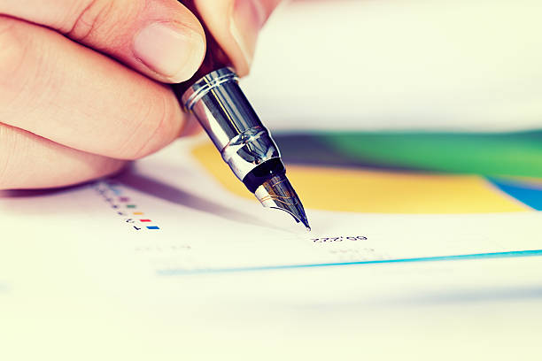 istock Financial document being carefully checked by hand with fountain pen 517194481