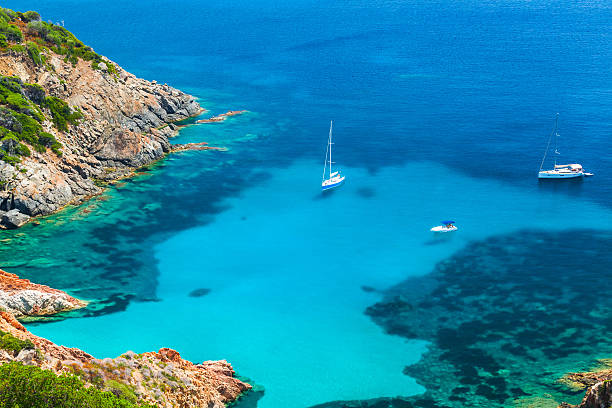 Corsica, Coastal summer landscape with yachts Corsica, French island in Mediterranean Sea. Coastal summer landscape, yachts moored in azure bay corsica photos stock pictures, royalty-free photos & images