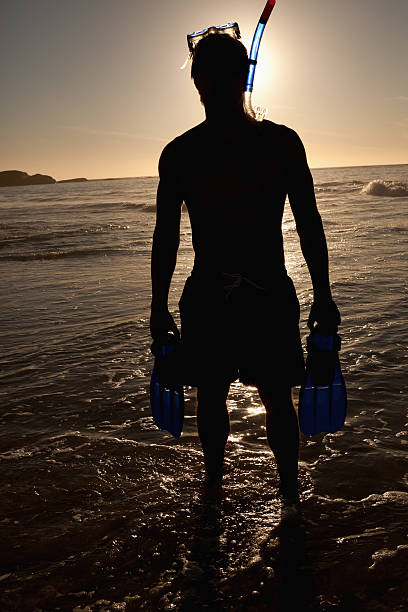 istock Young man standing in front of the ocean 517197881