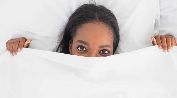 istock Pretty woman peeking from under the duvet 517197893