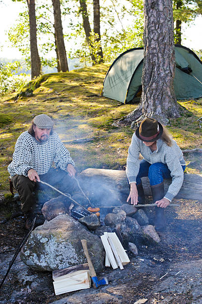 istock Senior couple grill sausages over camp fire 517200641