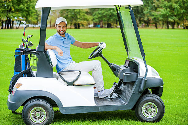 homem condução carrinho de golfe. - golf course golf people sitting imagens e fotografias de stock