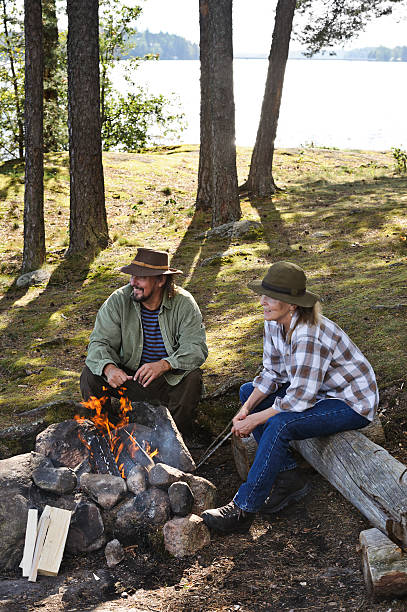 istock Senior couple sitting by camp fire 517215291