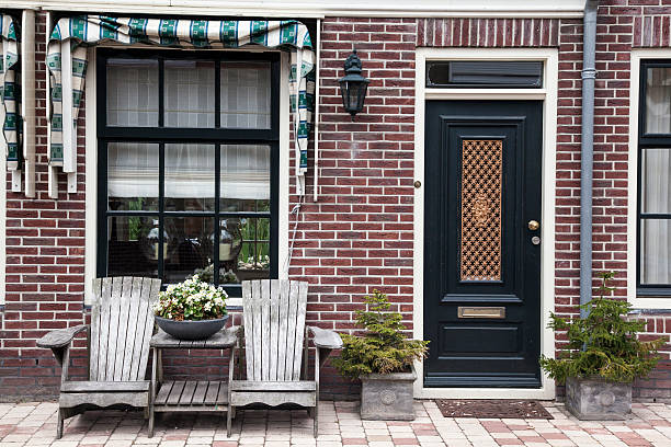 Front door and window of a house that falls under monument protection. On the left side of the door is the emblem that the house is a recognized monument in Nijkerk