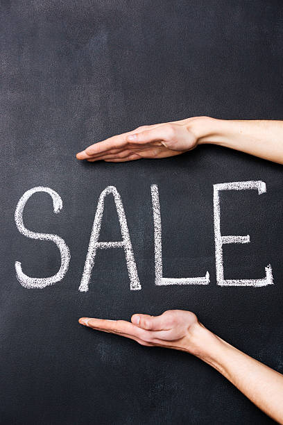 istock Two hands showing sale written on chalkboard 517221638