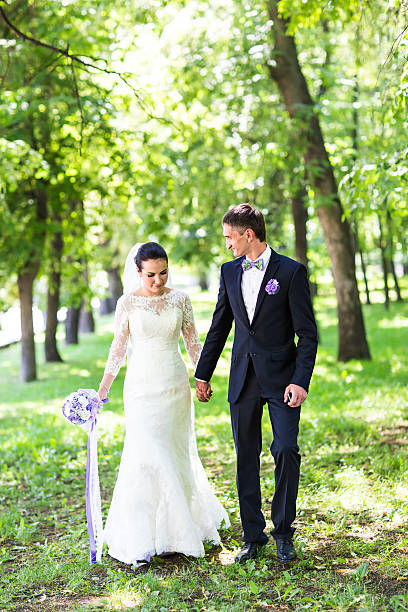 istock happy beautiful bride and groom walking on a park 517222060