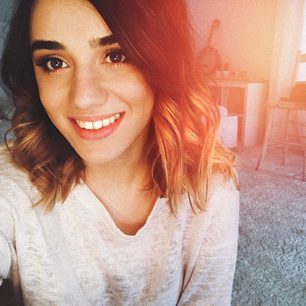 "selfie" - portrait of a beautiful young shy girl with curly hair - fotografias e filmes do acervo