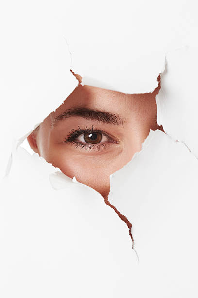 istock Young woman looking through tears in paper 517224696