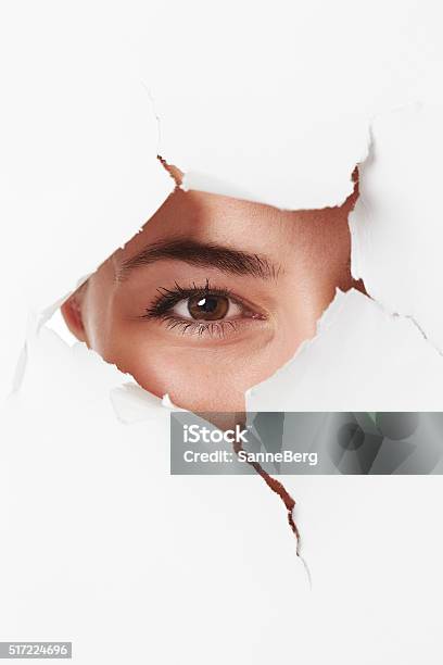 Young Woman Looking Through Tears In Paper Stock Photo - Download Image Now - 25-29 Years, Adult, Adults Only