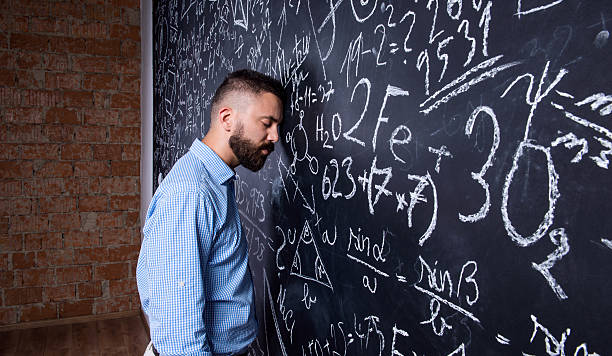 istock Tired teacher sleeping against big blackboard with mathematical 517225184