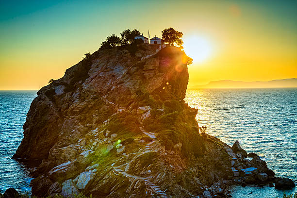 Rock with Agios Ioannis church on Skopelos island at sunrise stock photo