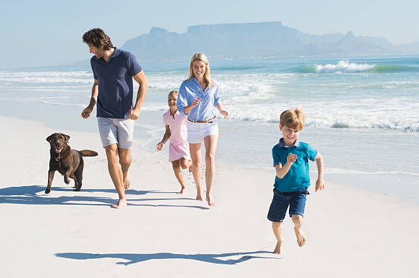 famiglia in esecuzione con cane - beach women joy sand foto e immagini stock