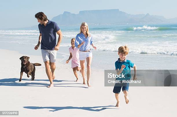 Family Running With Dog Stock Photo - Download Image Now - Dog, Family, Beach