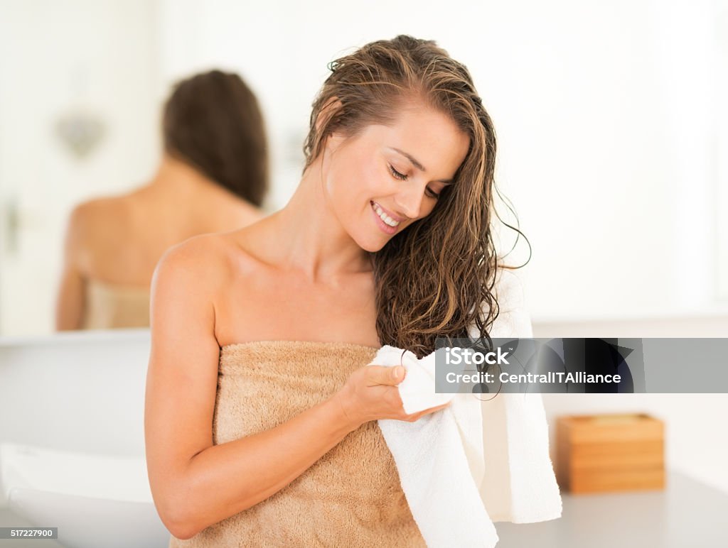 happy young woman wiping hair with towel in bathroom Happy young woman wiping hair with towel in bathroom Washing Stock Photo