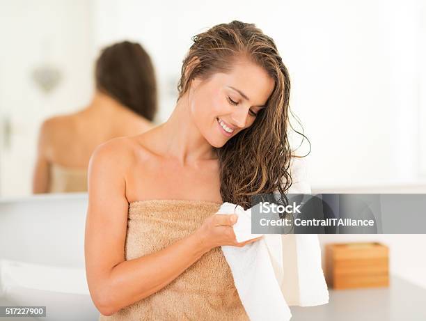 Happy Young Woman Wiping Hair With Towel In Bathroom Stock Photo - Download Image Now