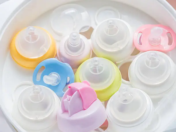 Nipple teethers and milk bottles in steam sterilizer and dryer. Steam sterilizer used for sterilize baby accessories by high temperature steam.