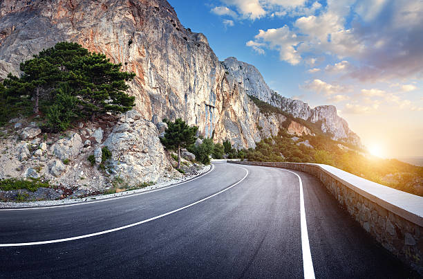 istock Winding mountain road with rocks, blue sky at sunset 517229230