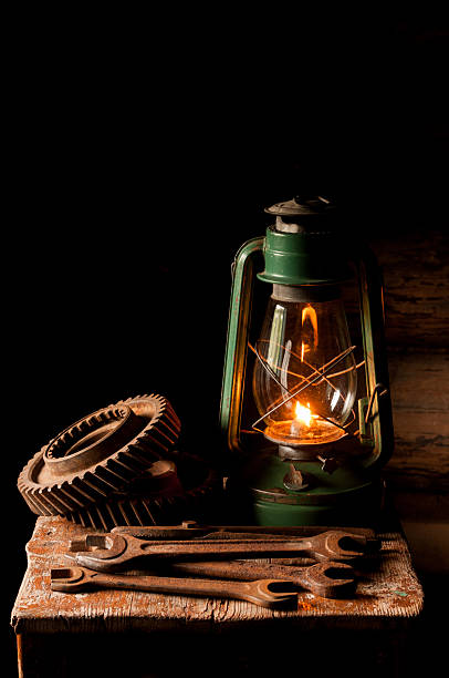 istock Vintage kerosene lamp and rusty gear on the  stool. 517230076