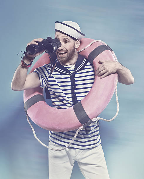 istock Bearded sailor holding lifebuoy, looking through binoculars 517232646