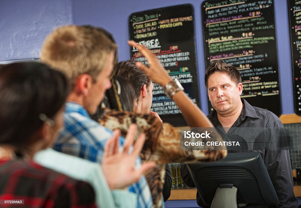 Annoyed Male Cafe Worker Annoyed male cafe worker with long line Customer Stock Photo