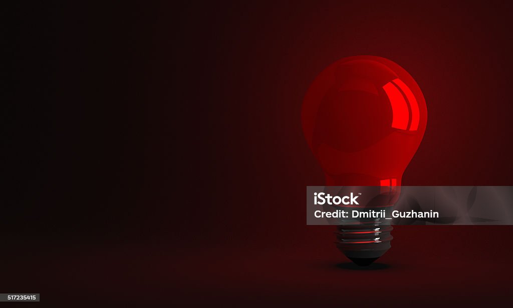 Red glowing light bulb on dark background Red glowing light bulb on dark textured background Concentration Stock Photo
