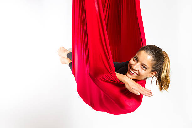 Young woman lying in hammock for anti-gravity aerial yoga stock photo