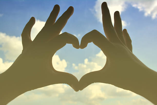 istock Hand heart shape silhouette on blue sky. 517236929