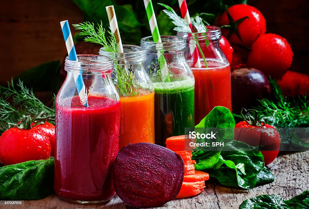 Freshly squeezed vegetable juice in bottles Freshly squeezed vegetable juice in bottles, useful vitamin cocktail, old wooden background, selective focus Bottle Stock Photo