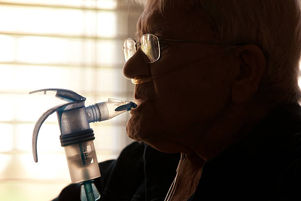älterer mann mit vernebler - nebulizer stock-fotos und bilder