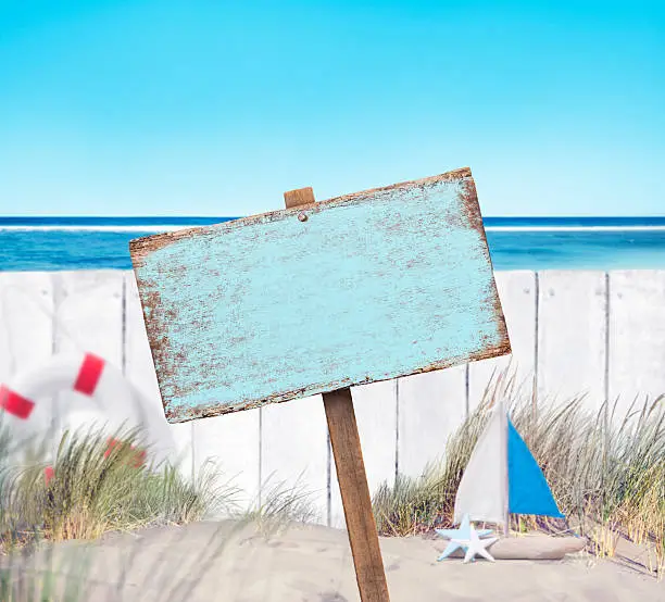 Photo of Empty Sign Board and Wooden Fence on Beach