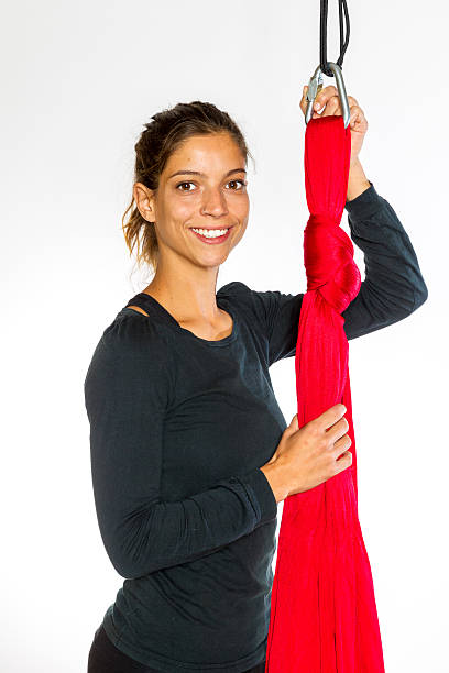 Young woman showing detail of hammock for anti-gravity aerial yoga stock photo