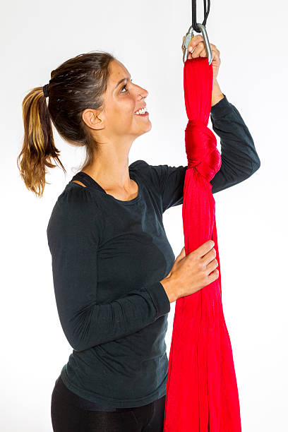 Young woman showing detail of hammock for anti-gravity aerial yoga stock photo