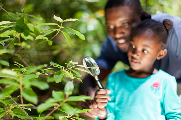 istock African father and daughter looking through a magnifying glass 517240907