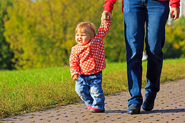 premiers pas d'adorables petite fille en plein air - baby first steps autumn child photos et images de collection