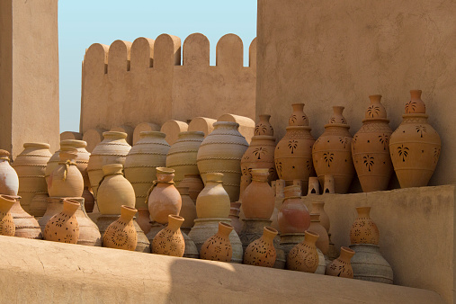 Pottery standing against an old wall in the Middle East (Nizwa, Oman)