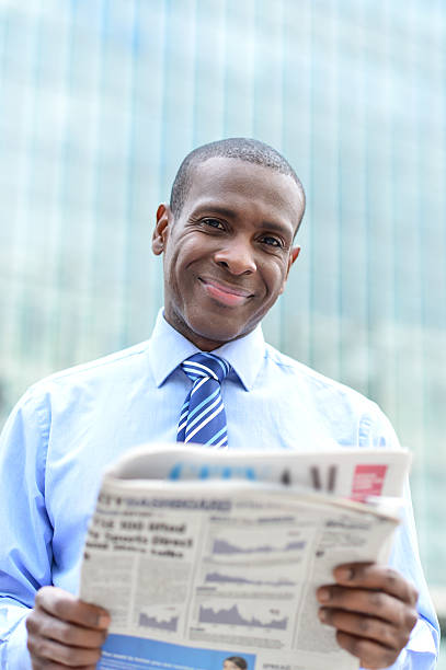 istock Handsome male executive reading a newspaper 517266741
