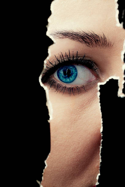 istock Young woman spying through a hole in the wall 517267593