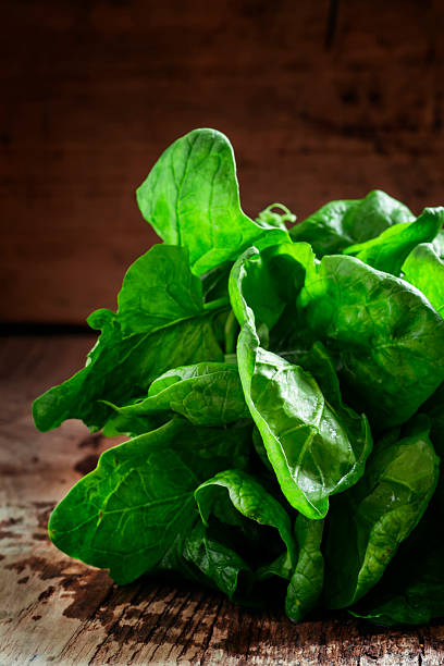 istock Freshly picked spinach on an old wooden table 517268438