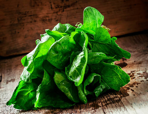 istock Freshly picked spinach on an old wooden table 517268596