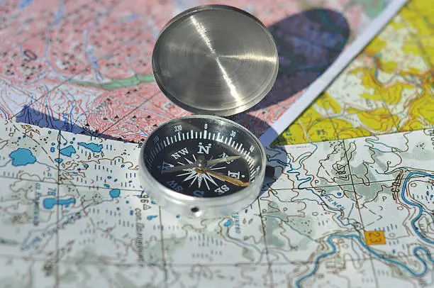 Compass, map. The magnetic compass is located on a topographic map.