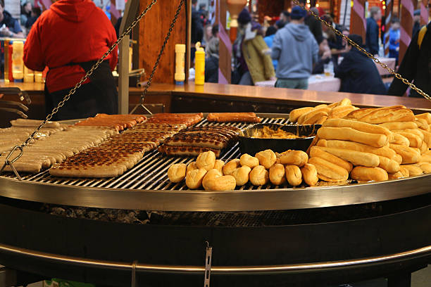 istock Image of bratwurst sausages and bread rolls warming on schwenkgrill 517271590