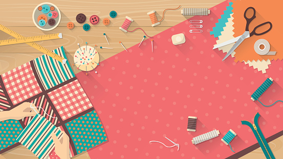 Seamstress working with quilting fabric, sewing equipment and fabric on a wooden worktop, sewing, hobby and creativity concept