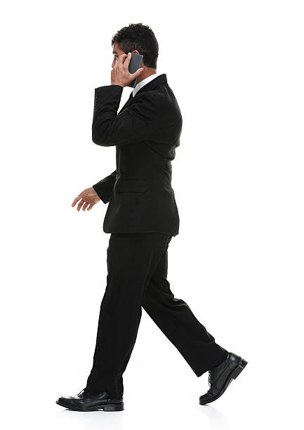 istock Smiling businessman on phone and walking 517274992
