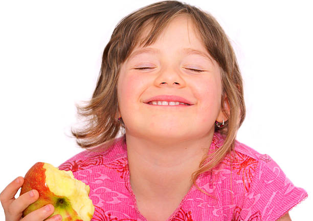 The child with great pleasure eat an apple. stock photo