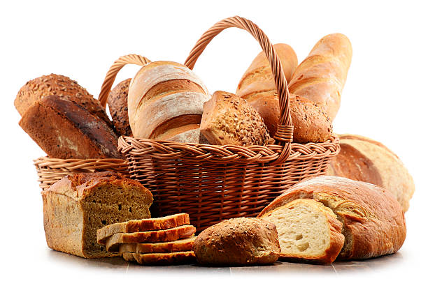 Wicker basket with assorted baking products isolated on white Wicker basket with assorted baking products isolated on white background loaf of bread stock pictures, royalty-free photos & images