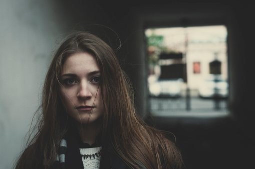 Young pensive long haired sacred girl standing outside alone