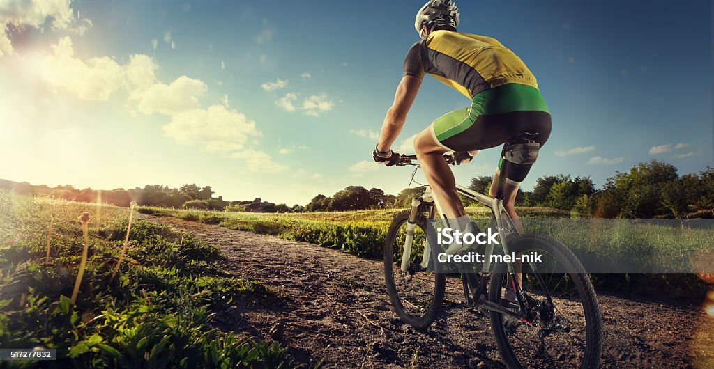 Cyclist riding a bike to the sunset on the ofroad Professional ofroad cyclist Cycling Stock Photo