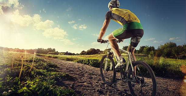 Cyclist riding a bike to the sunset on the ofroad Professional ofroad cyclist cycling shorts stock pictures, royalty-free photos & images