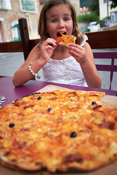 istock Girl eating Pizza 517283349